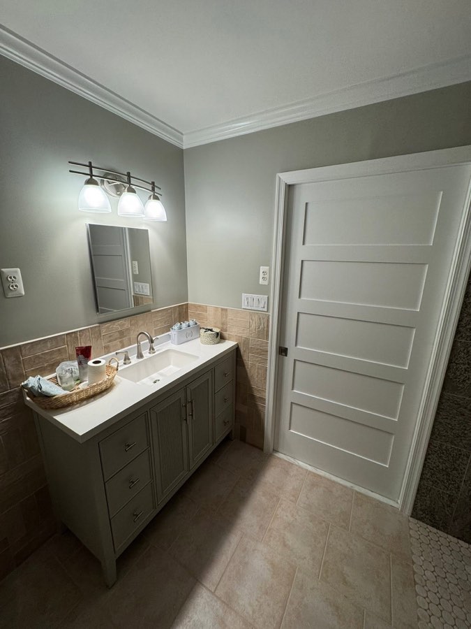 New vanity with quartz top, brushed nickel fixtures, and sand-toned tile wainscot